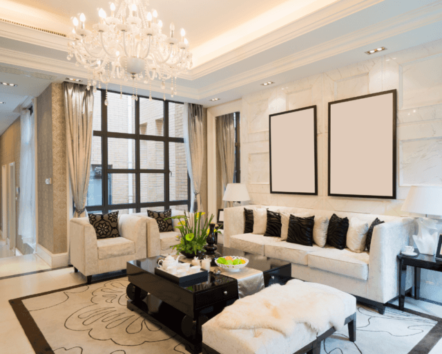Elegant living room with chandelier lighting, plush seating, large windows, and modern upscale interior design.